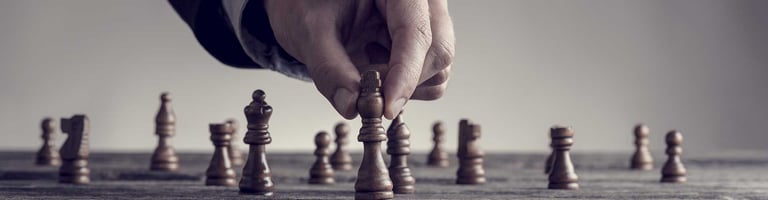 Nahaufnahme einer schachspielenden Hand mit Schachfiguren