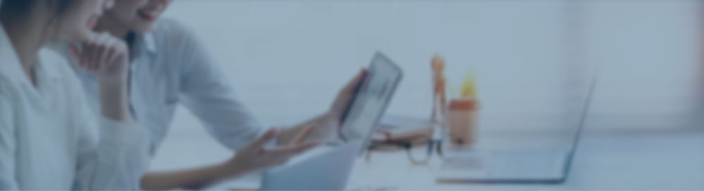 Zwei Frauen im Büro schauen auf einen Bildschirm und suchen ein DMS